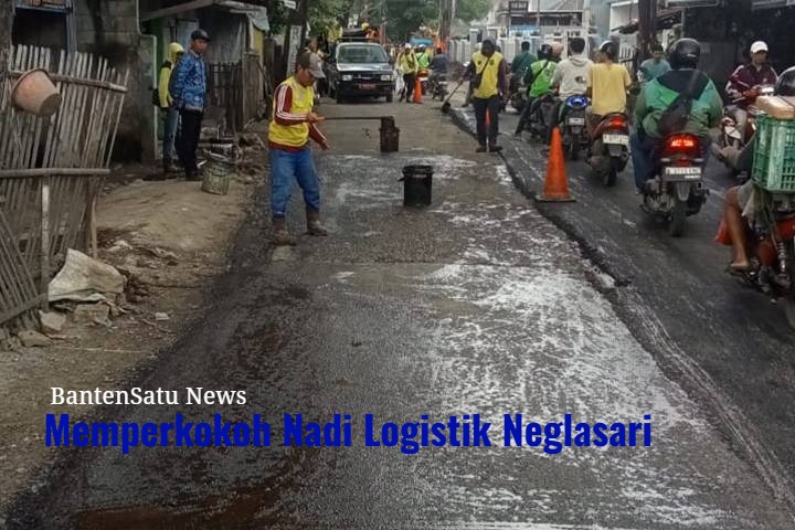 Dokumentasi pengerjaan pengaspalan Jalan Iskandar Muda menggunakan alat berat asphalt paver, memperlihatkan lapisan hotmix tebal yang siap menahan beban kendaraan berat.