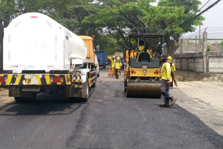 Petugas Dinas PUPR Kota Tangerang sedang melakukan pengaspalan dan perbaikan lubang di Jalan Pajajaran Jatiuwung demi kelancaran lalu lintas.