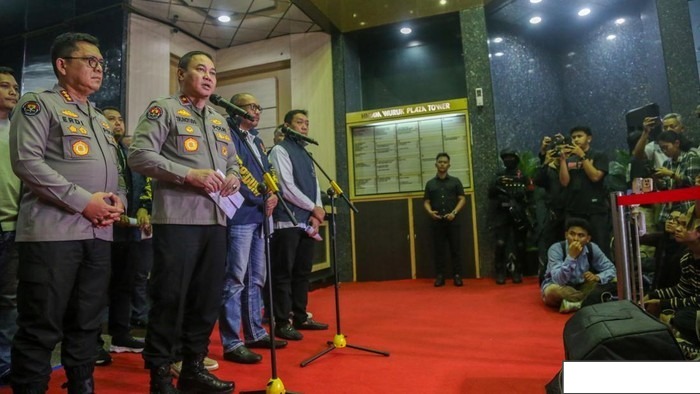 Barang bukti berupa tumpukan uang tunai berbagai mata uang, laptop, dan paspor yang disita Polri dari markas judi online Hayam Wuruk.