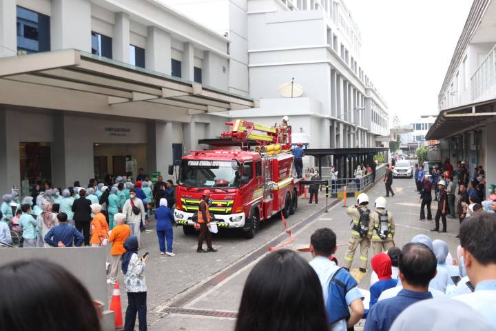 Petugas BPBD Kota Tangerang bersama staf medis Primaya Hospital sedang melakukan simulasi evakuasi pasien menggunakan tandu darurat menuruni tangga darurat gedung rumah sakit.