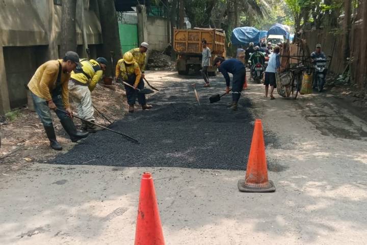 Suasana pengerjaan pengaspalan ulang oleh petugas Dinas PUPR di ruas Jalan Raya Sangego-Bayur Tangerang.