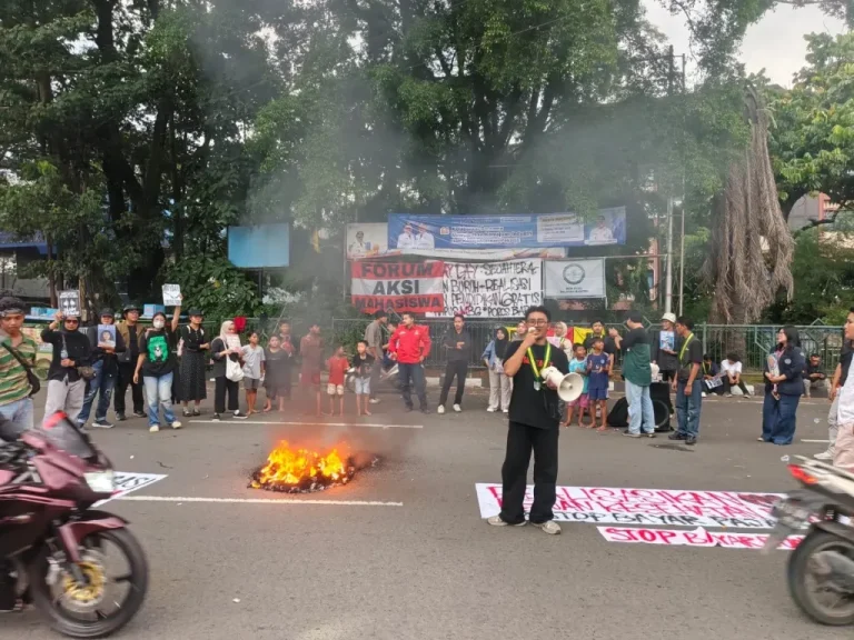 Massa aksi Poros Baru Tangerang saat membentangkan spanduk tuntutan dalam peringatan May Day 2026 di Taman Gajah, menyerukan perlindungan hak pekerja dan keselamatan siswa.