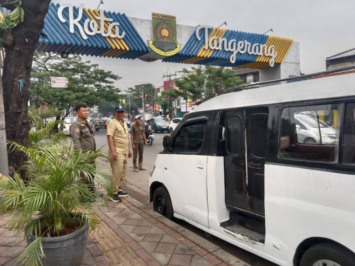 Petugas Trantib Kecamatan Larangan menegur pengemudi angkutan umum yang parkir sembarangan di bahu Jalan HOS Cokroaminoto dekat tugu perbatasan Kreo.