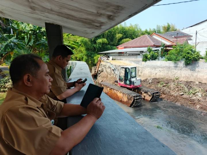 Alat berat Dinas PUPR Kota Tangerang melakukan pengerukan lumpur di Kali Cantiga Larangan.