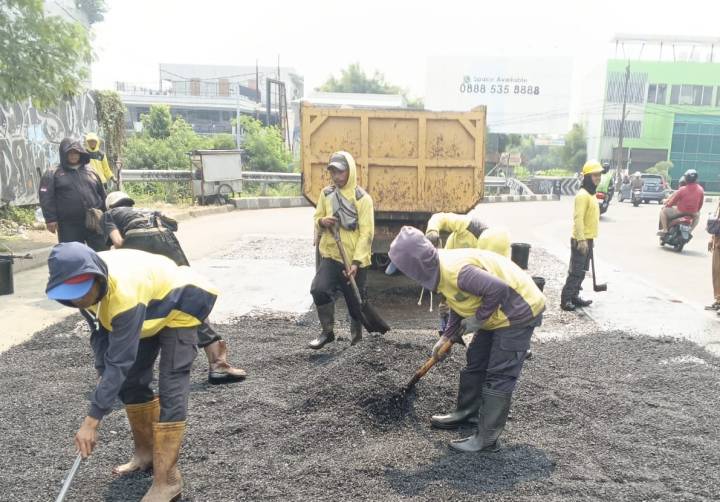 Petugas Dinas PUPR Kota Tangerang melakukan proses perbaikan Jalan HOS Cokroaminoto, Kecamatan Larangan, Kota Tangerang, Provinsi Banten.