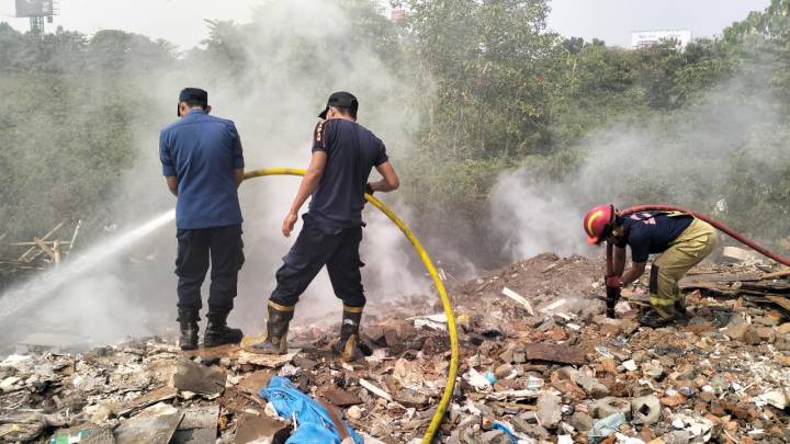 Petugas Damkar Kota Tangerang memadamkan kebakaran lahan kosong di Pondok Bahar yang materialnya tertimbun puing hingga dua meter.